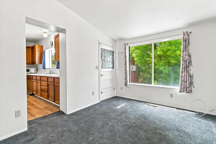 Carpeted living area with a large window and white trim