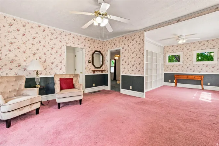 Spacious interior featuring wall-to-wall carpeting and floral wallpaper with a contrasting lower wall panel