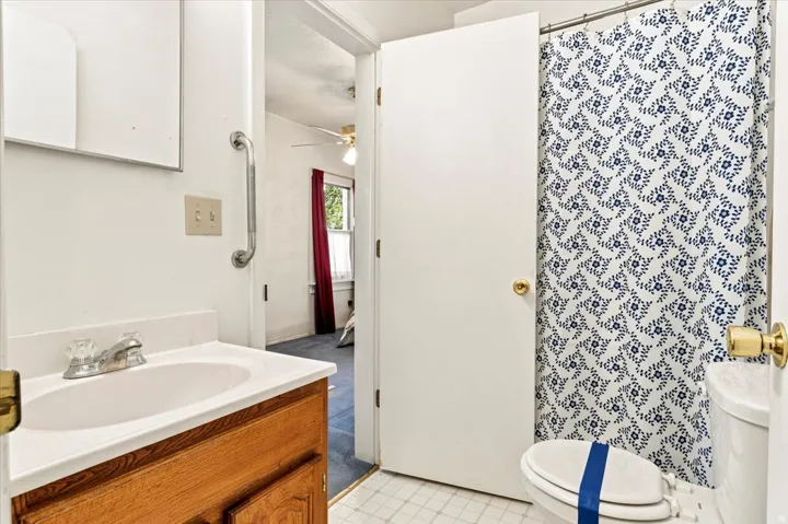 Bathroom featuring a single vanity with wood-finish cabinetry, a white countertop, and a white basin