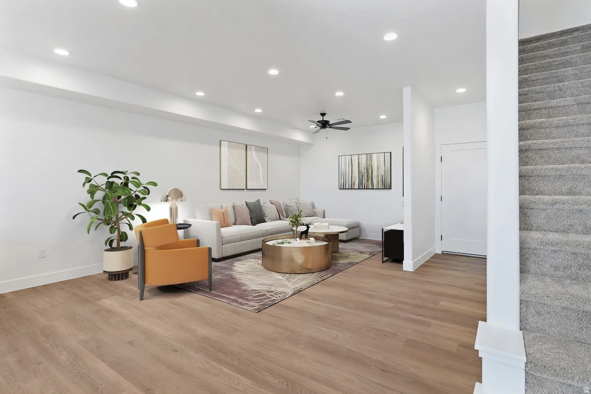 Spacious living area featuring wood-finish flooring, recessed lighting, and a modern ceiling fan