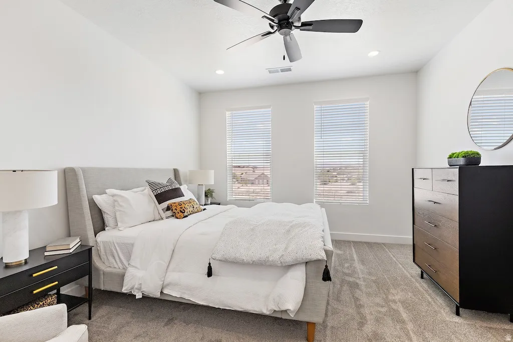 Carpeted room featuring a ceiling fan with light, recessed lighting, and two windows