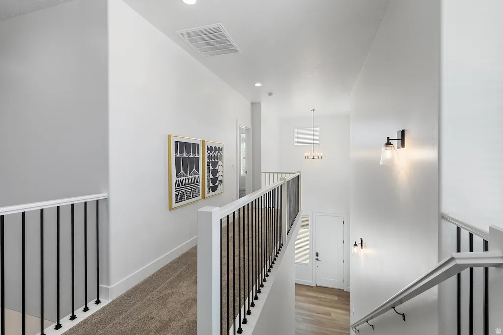 Upper-level hallway featuring plush carpet flooring
