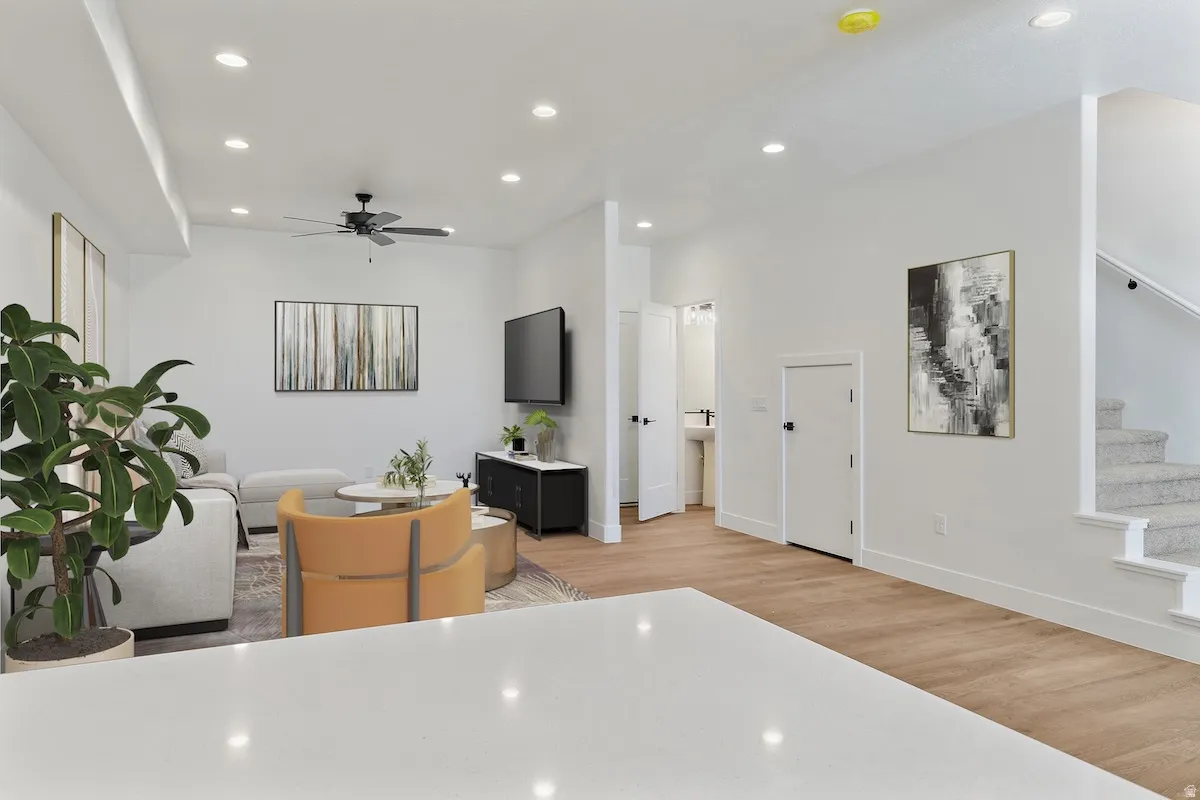 Open-concept living space with recessed lighting, wood-finish flooring, a ceiling fan, and white walls