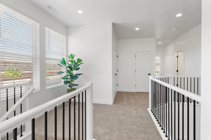 Upper-level hallway featuring a neutral carpet, white walls, and recessed lighting