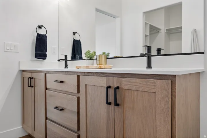 Double vanity with a white countertop and two matte black faucets