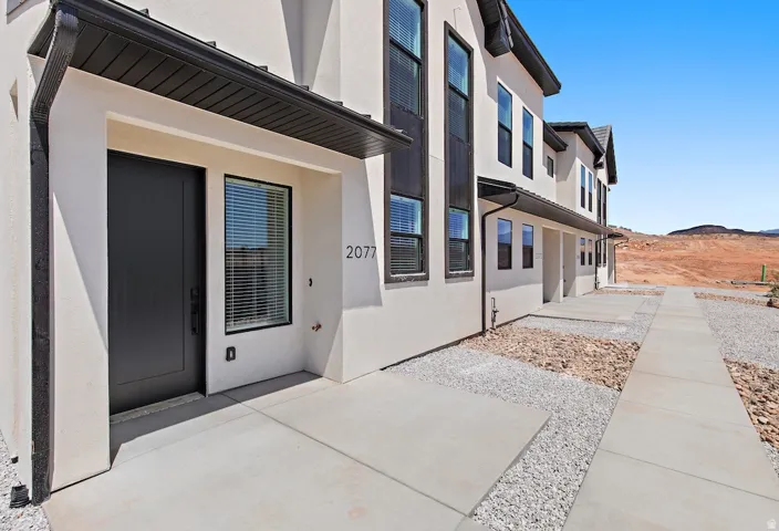 Contemporary stucco exterior with dark trim and black front door