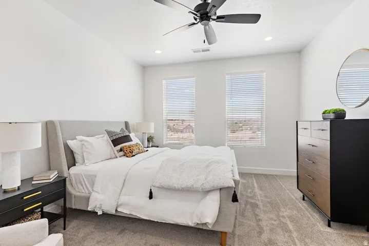 Carpeted room featuring a ceiling fan with light, recessed lighting, and two windows