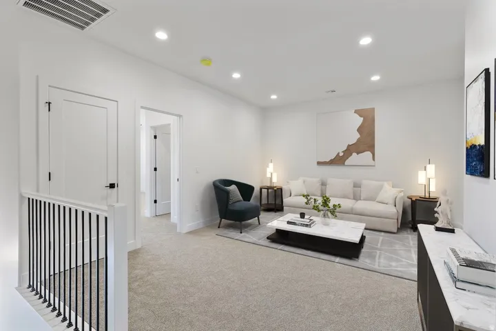 Spacious room with recessed lighting, light-toned carpeting, and white walls