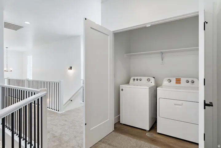 Dedicated laundry closet with included washer and dryer, featuring a convenient overhead shelf