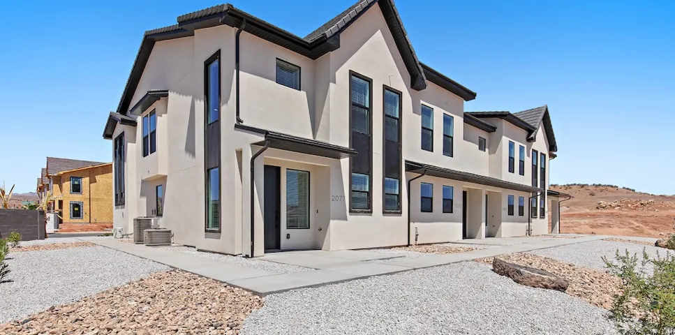 Modern stucco exterior with contrasting dark trim and multiple tall windows