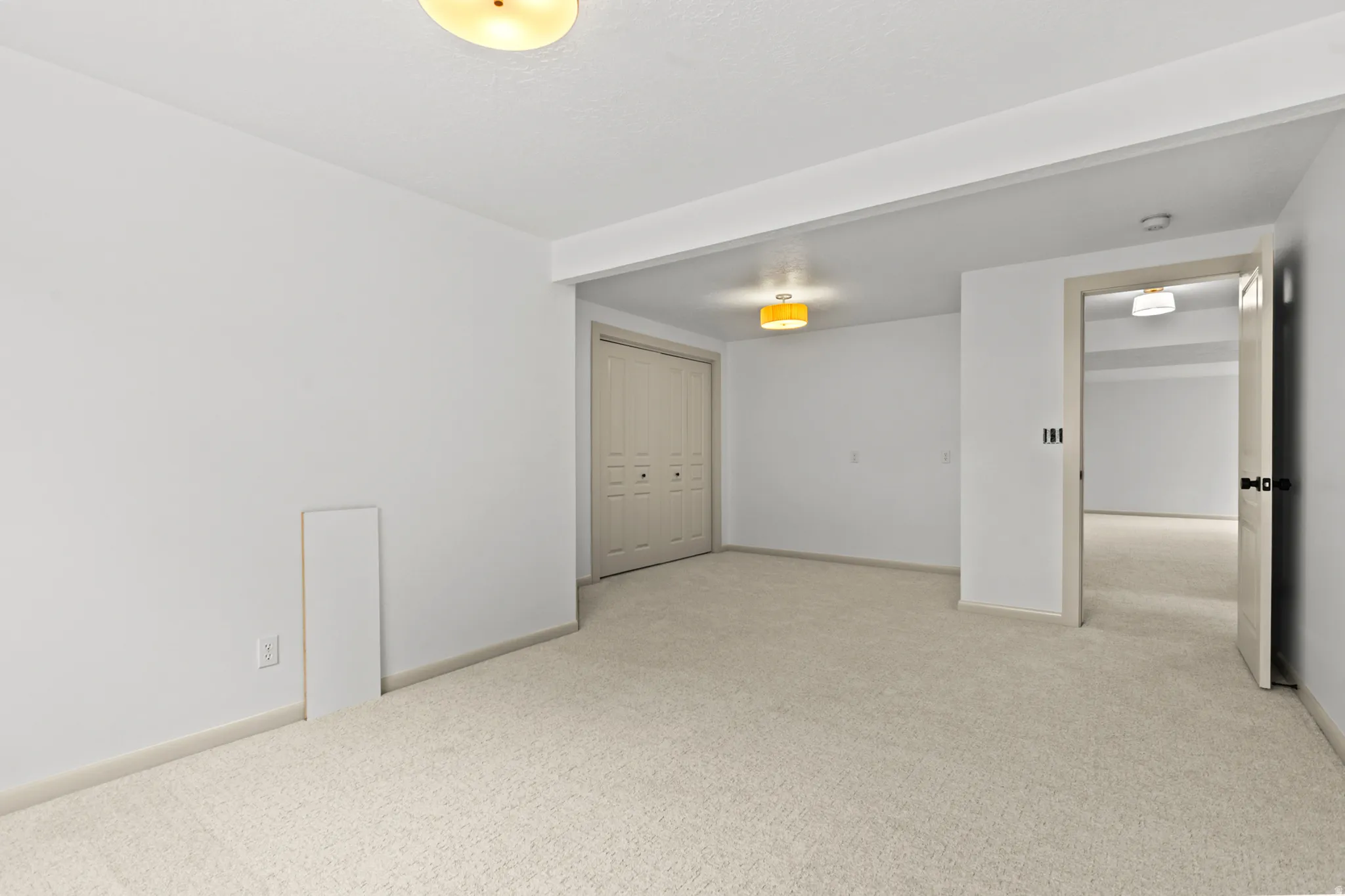 Spacious room with plush carpeting, neutral wall finishes, and a flush-mount ceiling light