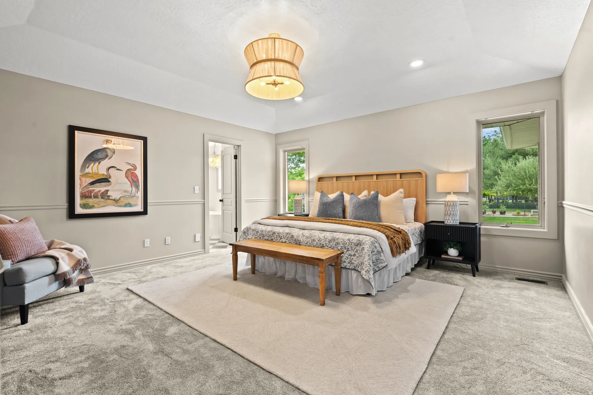 Spacious room featuring tray ceiling, recessed lighting, and wall paneling