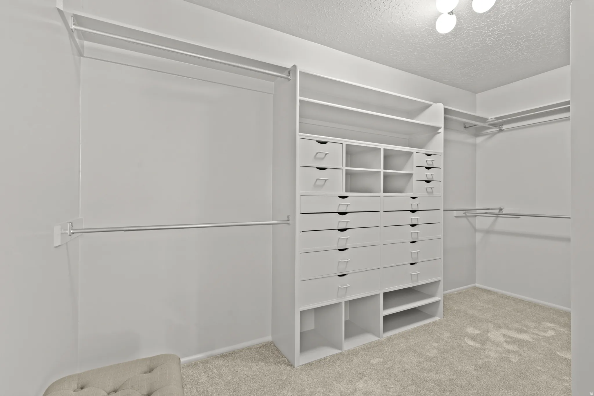 Custom closet system featuring multiple drawers, open shelving, and hanging rods