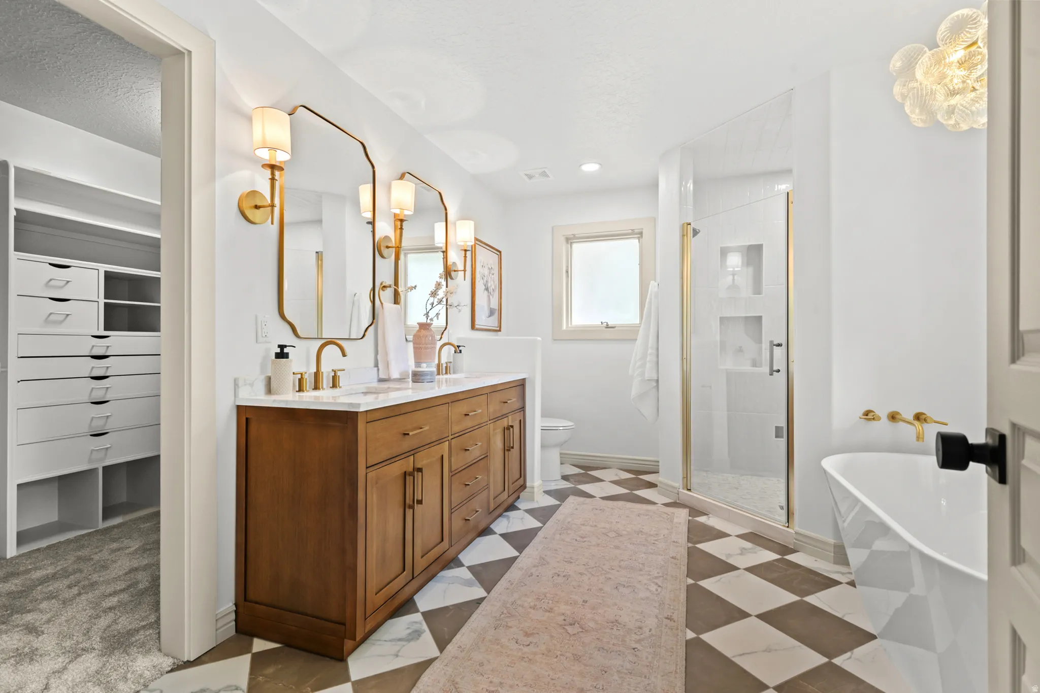 Dual vanity with gold-finish fixtures and framed mirrors
