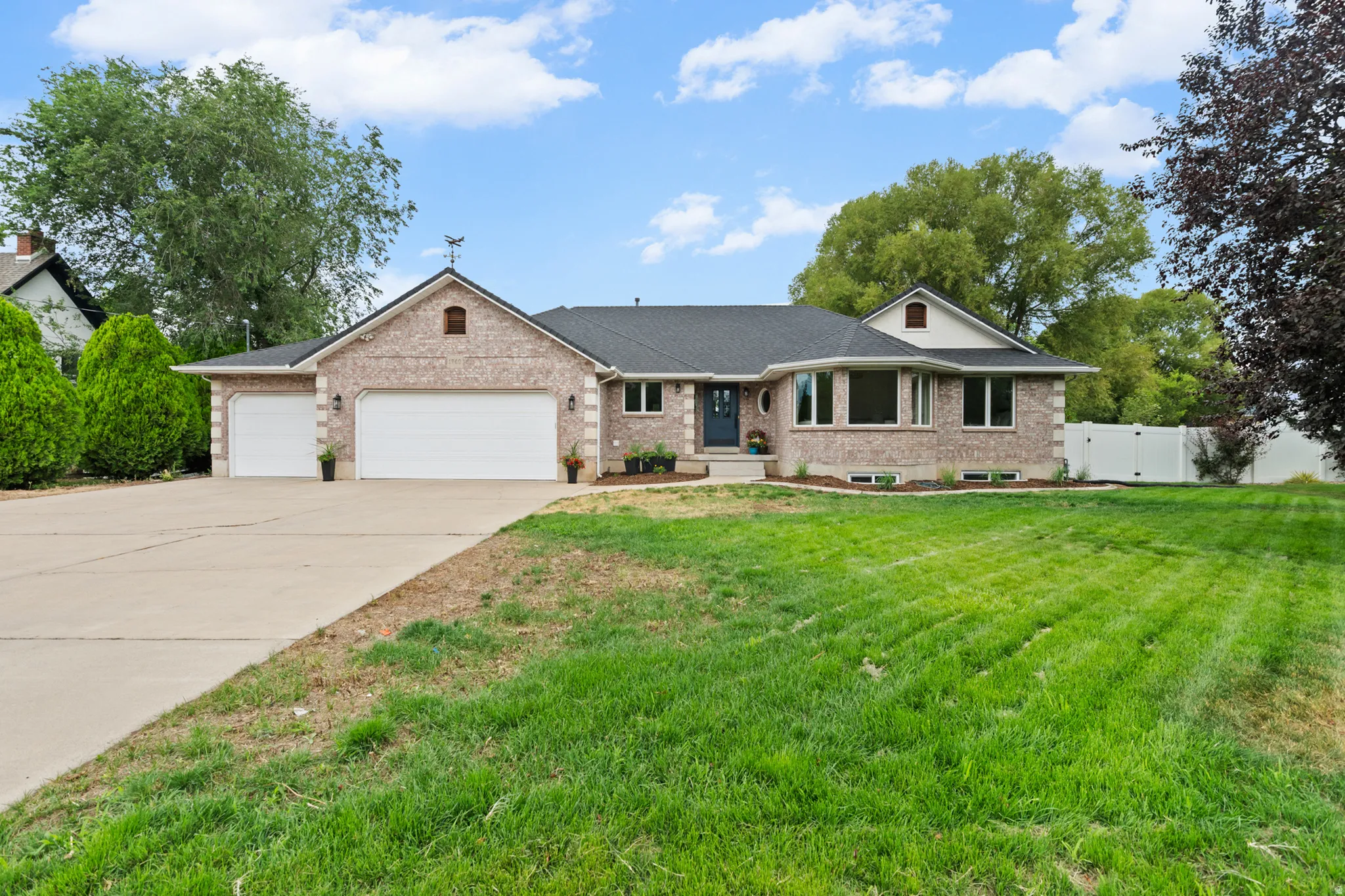 Brick exterior with a dark roof and a three-car garage