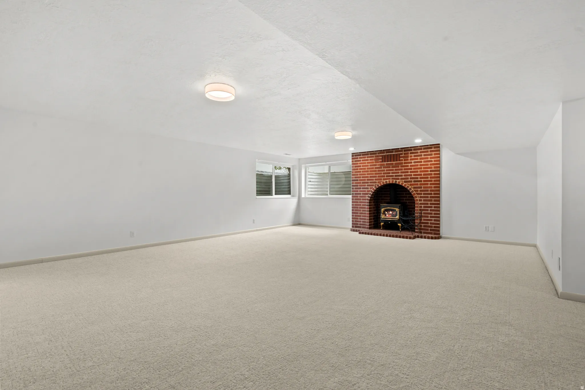Spacious room featuring light-toned carpeting and white painted walls
