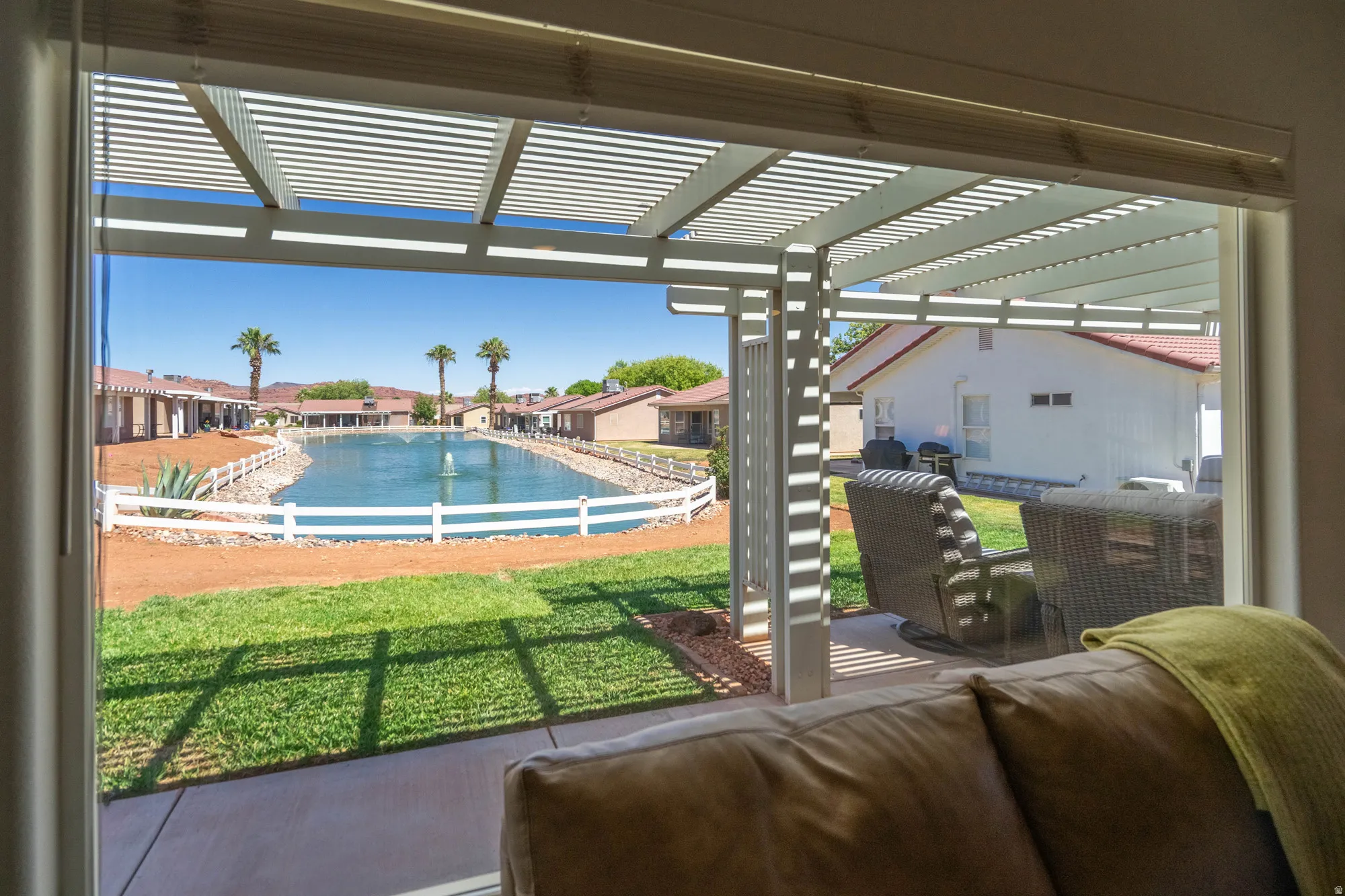 Sliding glass doors opening to a covered patio with a slatted pergola