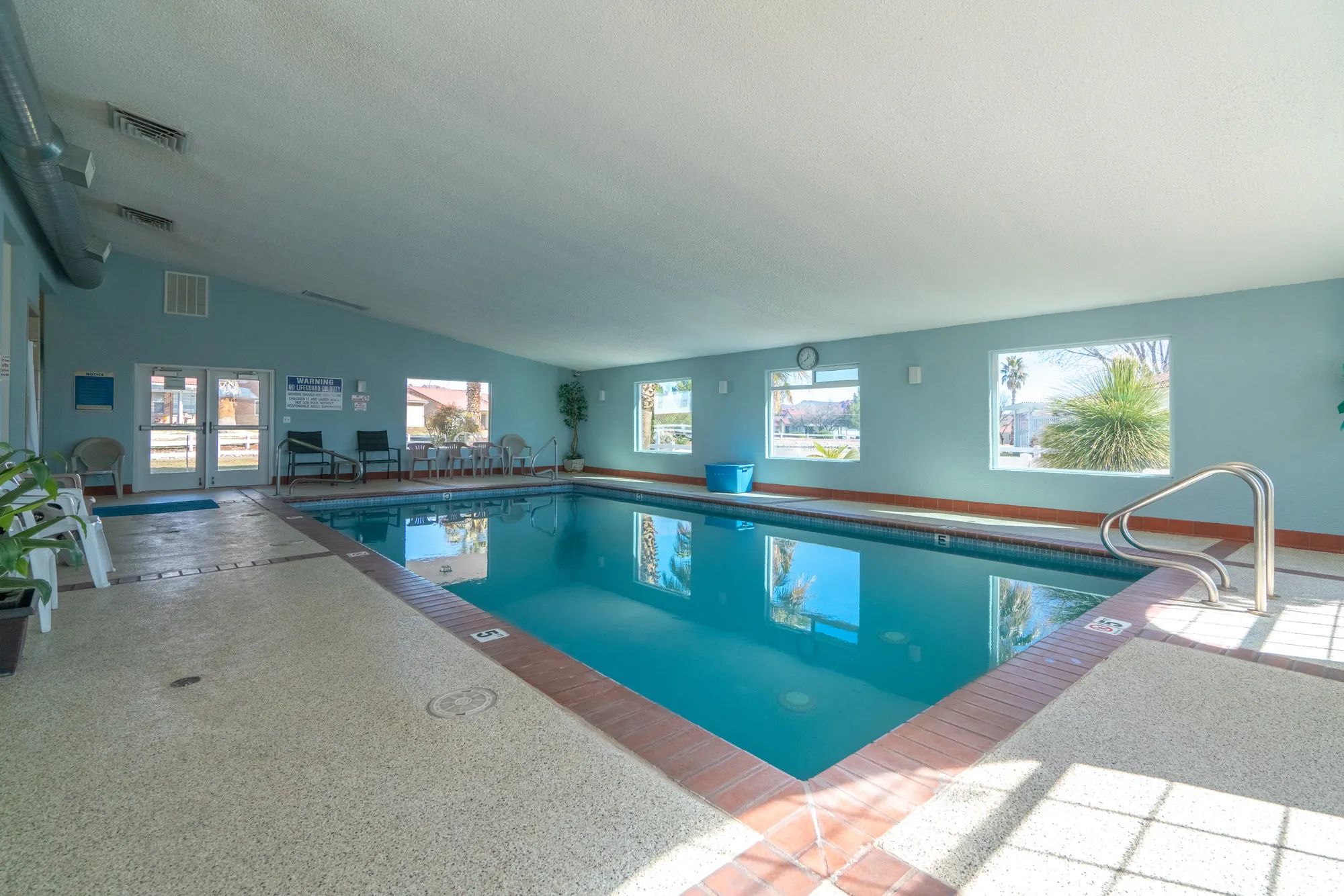 Indoor swimming pool with a textured deck surround and brick coping