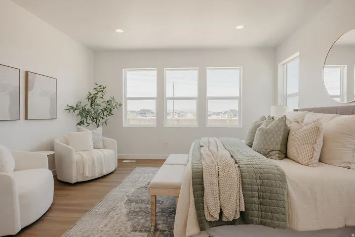 Room featuring wood-finish flooring, recessed lighting, and a series of three windows