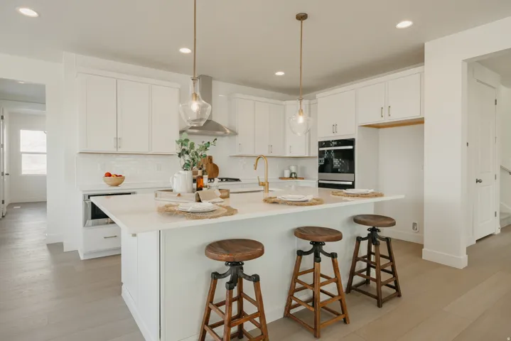 Spacious kitchen featuring white cabinetry, light wood-finish flooring, recessed lighting, and a kitchen island with pendant lighting