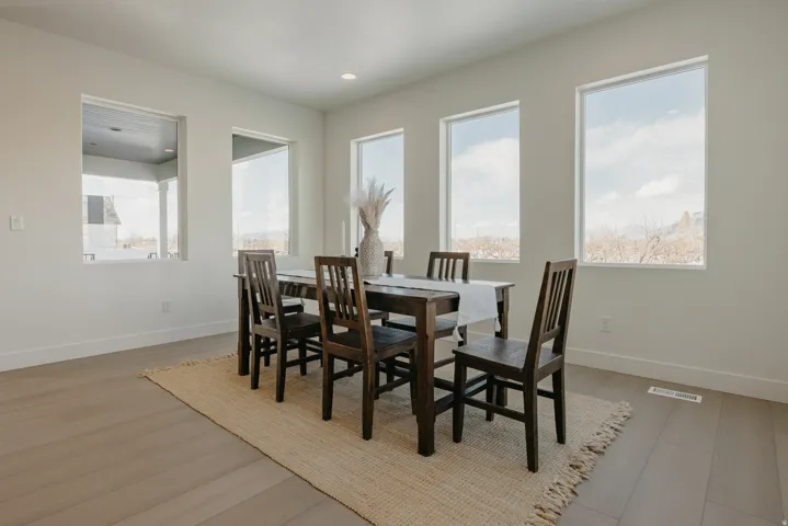 Bright interior space featuring multiple large windows, recessed ceiling lighting, and wood-finish flooring