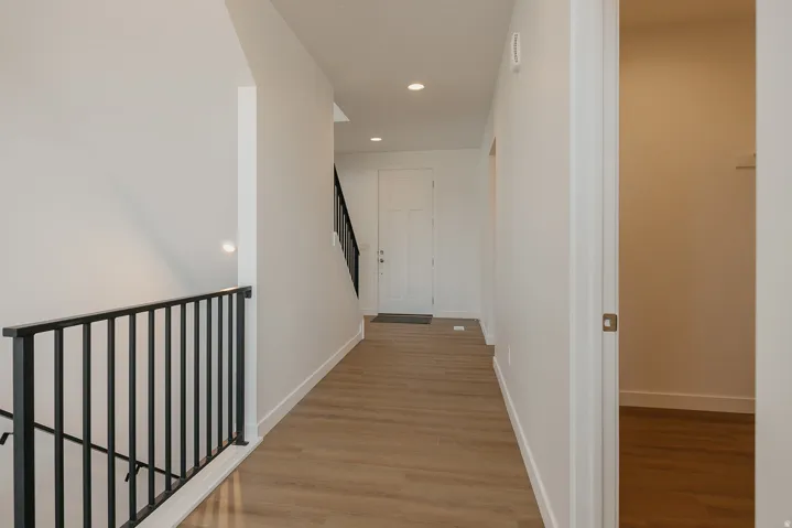 Entryway featuring wood-finish flooring, recessed lighting, and a modern black metal stair railing