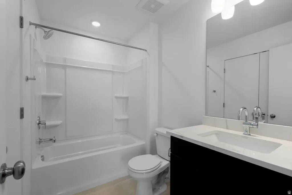 Bathroom featuring a single vanity with dark cabinetry, integrated sink, and light-toned countertop