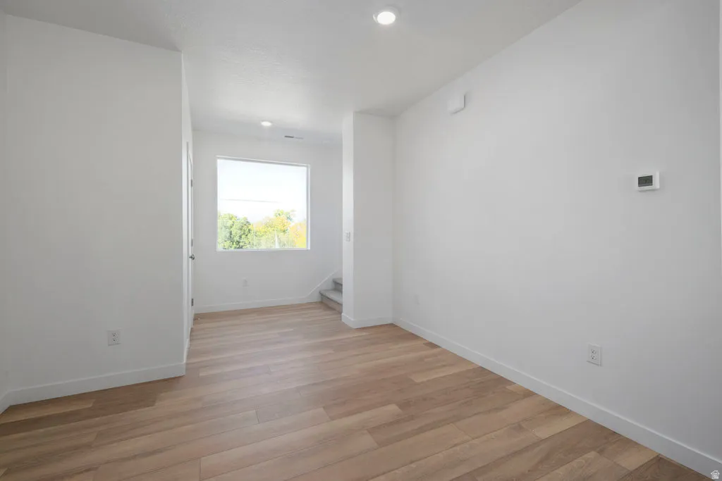 Entryway featuring wood-finish flooring, white walls, and recessed lighting