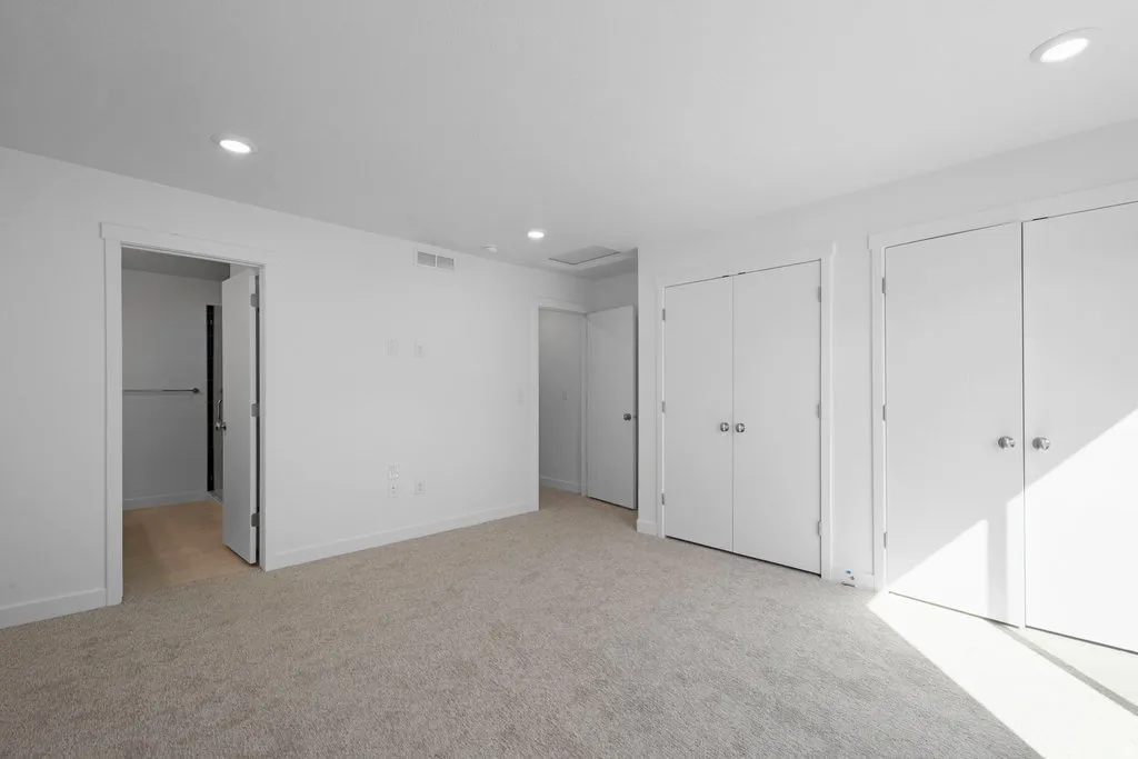 Spacious room featuring neutral carpeting and white walls