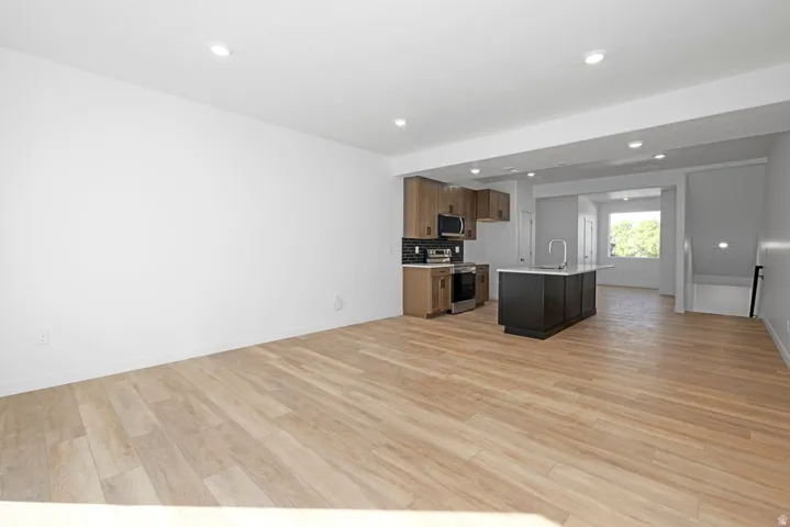 Open-concept living space featuring wood-finish flooring, recessed lighting, and a contemporary kitchen