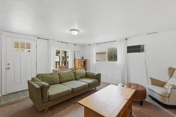 Living area featuring light brown carpet flooring and white painted walls