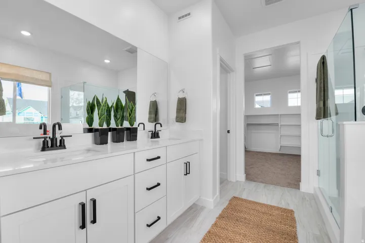 Dual vanity with crisp white cabinetry, quartz countertops, and matte black fixtures