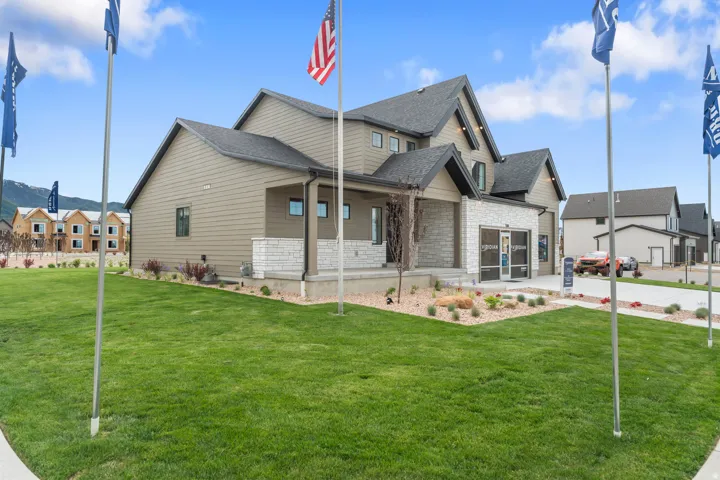 Contemporary exterior featuring tan siding, a dark shingle roof, and light-colored stone accents