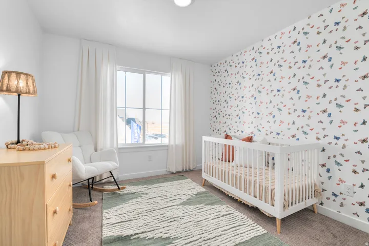 Bright room featuring a large window with white trim, a decorative accent wall, neutral carpeting, and a recessed ceiling light