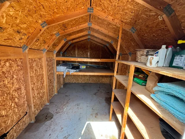 Interior of a storage shed with exposed wood framing and OSB paneling
