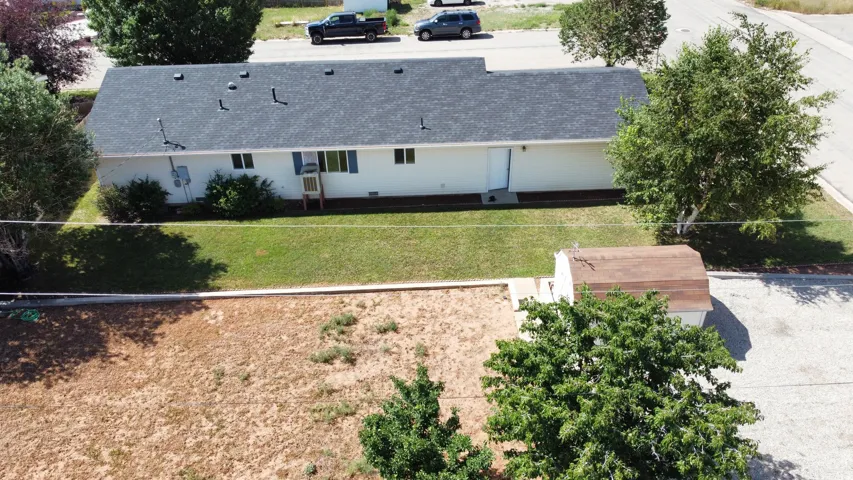 Ranch-style exterior with a dark shingle roof and light-colored siding