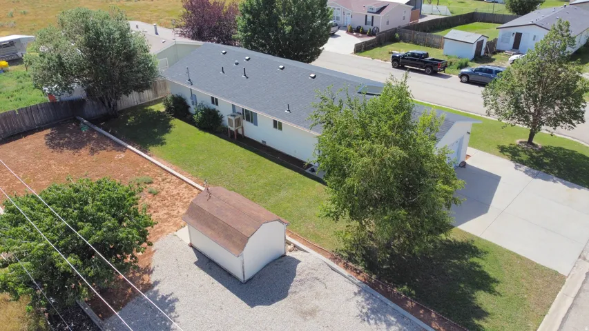 Single-story residence featuring a dark shingle roof, light-colored siding, and a concrete driveway