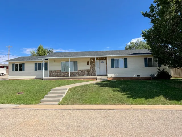 Ranch-style residence featuring a stone and siding exterior, covered front porch, and a concrete pathway leading to the entrance