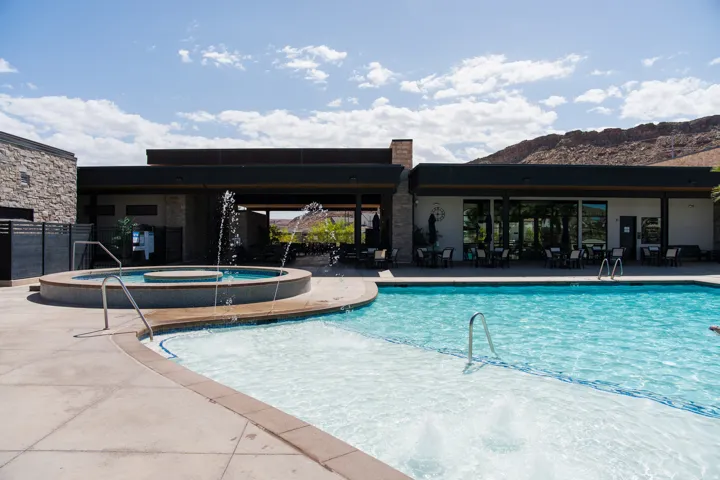 Resort-style pool area featuring a large swimming pool and a separate spa with water features