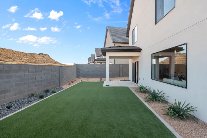 Expansive artificial turf lawn bordered by decorative rock and low-maintenance plantings