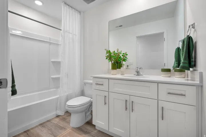 Bathroom featuring a white vanity with slab countertop, undermount sink, and chrome faucet