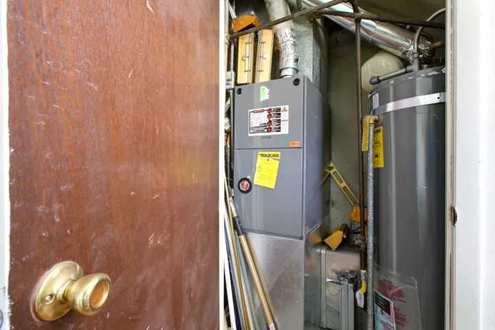 Utility closet featuring a water heater and furnace