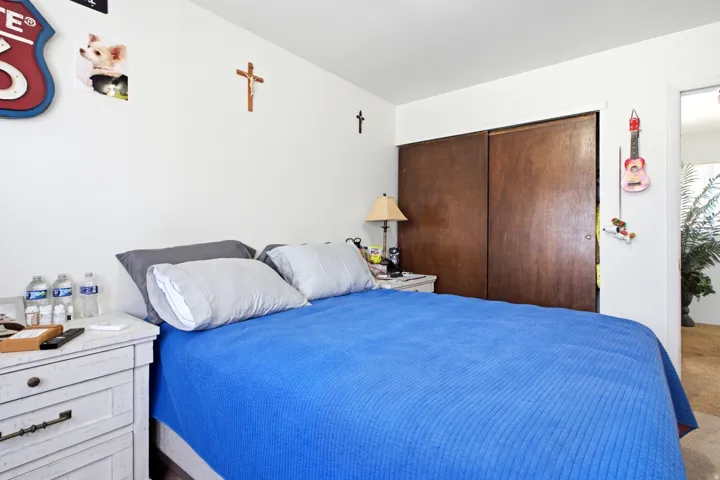 Bedroom featuring white walls and wood-finish sliding closet doors
