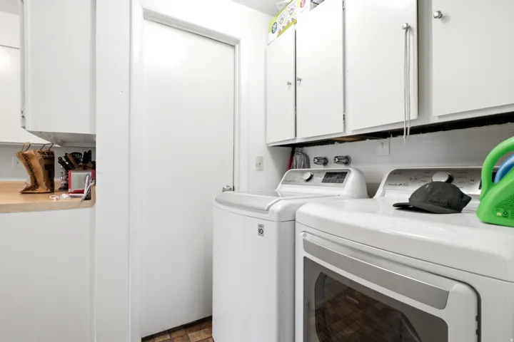 Dedicated laundry area featuring white upper cabinetry and a full-size appliance space