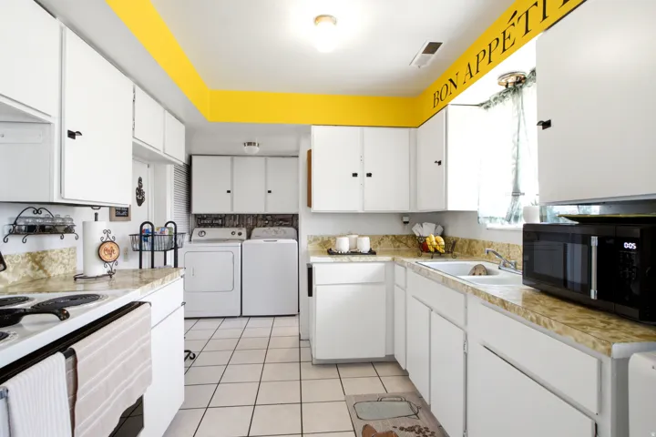 Bright kitchen featuring white cabinetry and light-colored countertops