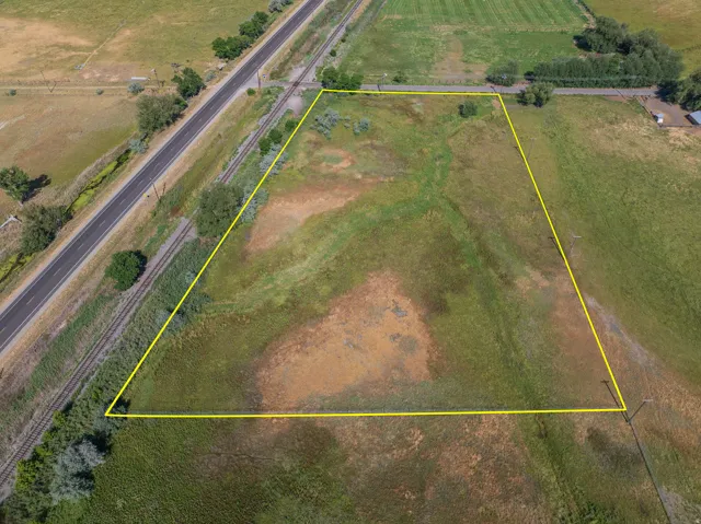 Expansive undeveloped parcel featuring varied ground cover and mature trees