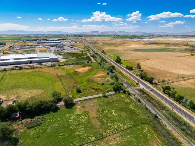 Expansive land parcel featuring open fields and distant mountain ranges under a clear sky