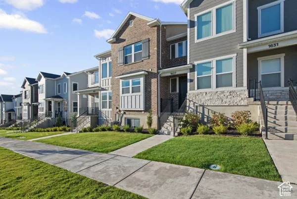 Brick and siding exteriors, multiple window configurations, front entry stairways with metal railings, landscaped front yards, and concrete sidewalks