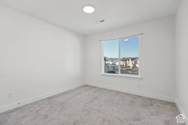 Wall-to-wall carpeting, white walls, and a large window with white trim