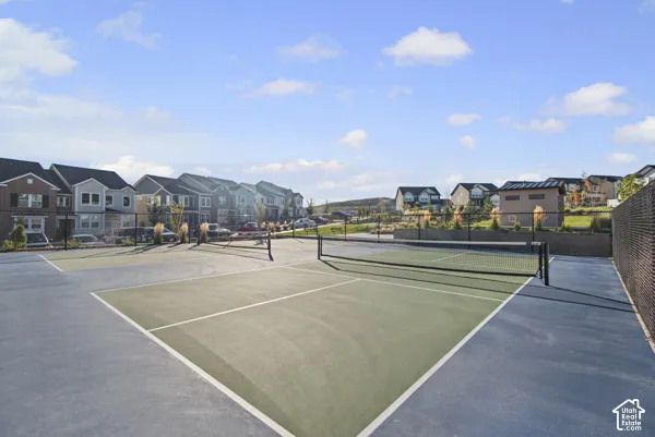 Multi-sport court with a net, enclosed by a chain-link fence